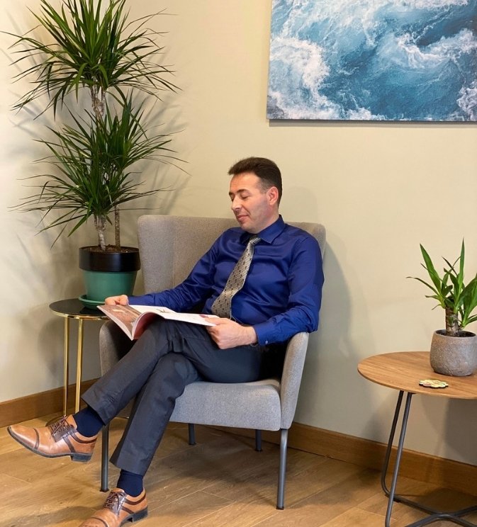 Dr. Kürşat Gül’ün klinik ortamda otururken çekilmiş profesyonel tanıtım fotoğrafı